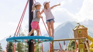 Spielplatz mit Blick auf die Tiroler Berge im Familotel Kaiserhof Spielparadies für Kinder mit Blick auf die Tiroler Berge – Familotel Kaiserhof